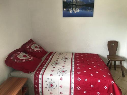 a bedroom with a bed with a red and white blanket at Samoëns studio 4 personnes idéalement situé in Samoëns
