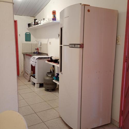 a kitchen with a white refrigerator in a room at Casinhas de Pipa Miró in Pipa