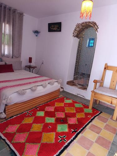 a bedroom with a bed and a rug and a chair at daryemma2 in Asilah