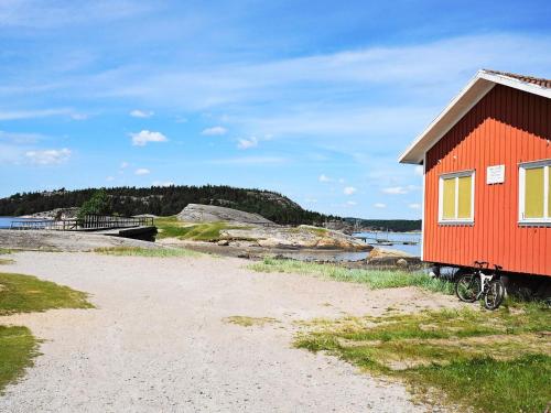 a red house with a bike parked next to a beach at 4 person holiday home in HENÅN-By Traum in Henån