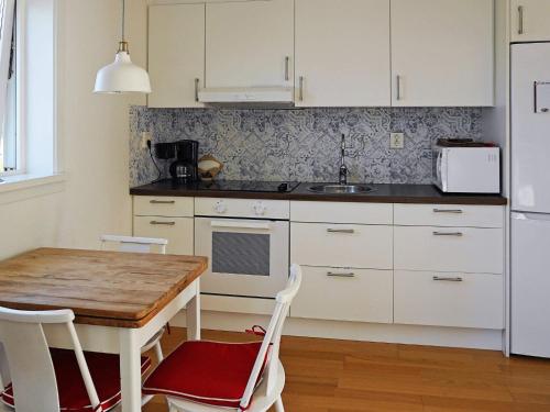 a kitchen with a wooden table and white cabinets at 4 person holiday home in HENÅN-By Traum in Henån