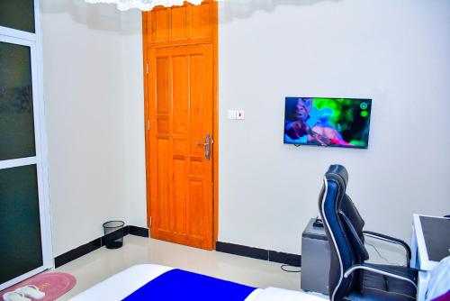 a room with a chair and a wooden door at KER HOTEL Dodoma in Dodoma
