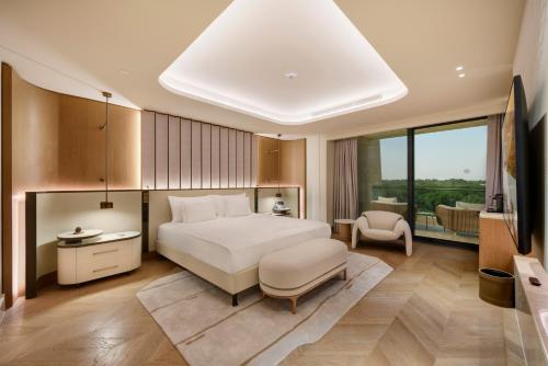 a bedroom with a large white bed and a chair at Regnum The Crown in Belek