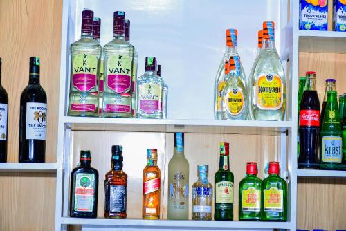 a shelf filled with lots of bottles of alcohol at KER HOTEL Dodoma in Dodoma