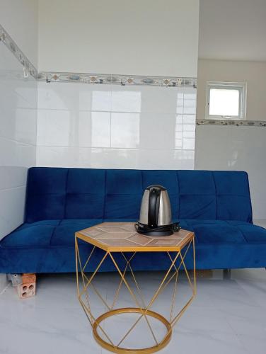 a blue couch with a coffee table in a living room at Vibi motel in Phan Thiet