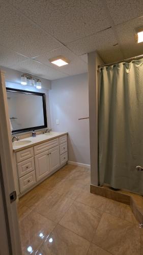 an empty bathroom with a sink and a mirror at 2 bedrooms with movie theater in Agawam