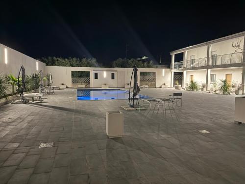a large courtyard with tables and chairs at night at Omai suite in Ortona