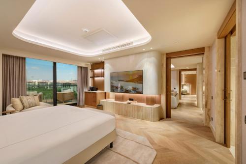 a bedroom with a large white bed and a tub at Regnum The Crown in Belek