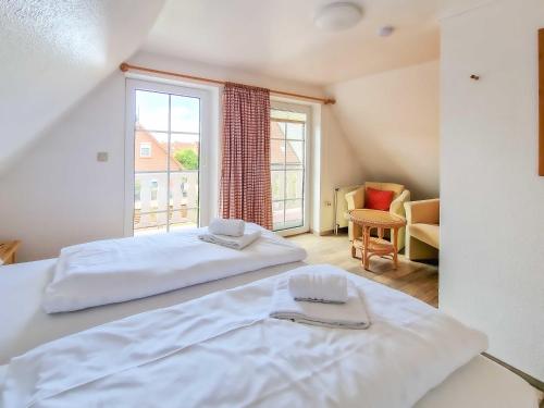 a bedroom with two beds and a large window at Gretel in Greetsiel