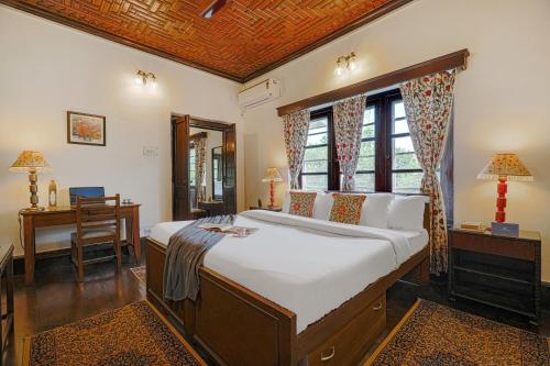 une chambre avec un grand lit et un bureau dans l'établissement SaffronStays Awakening Suite, à Srinagar