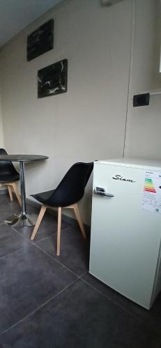 a chair sitting next to a table and a refrigerator at aleyluna in Berrotarán
