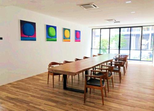 a conference room with a long wooden table and chairs at SoulHealingPlace Galacity 2BR 2Bed Apartment in Kuching
