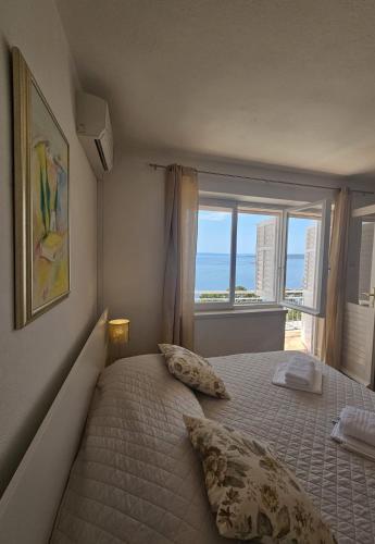 a bedroom with a bed with a view of the ocean at Apartments Lusi in Brela