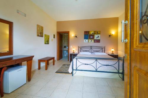 a bedroom with a bed and a desk and a television at Hotel Epavlis in Káto Poróïa