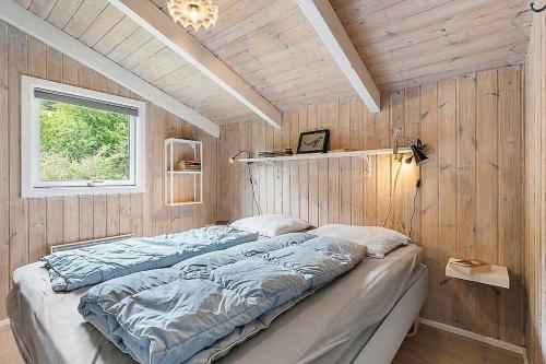 a bedroom with a large bed in a wooden wall at BL1052-Blokhus-Berberisvej-22 in Blokhus