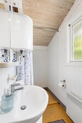 a white bathroom with a sink and a window at BL1052-Blokhus-Berberisvej-22 in Blokhus