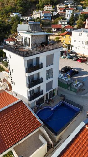 an aerial view of a white building with a swimming pool at Relax Apartmani in Sutomore