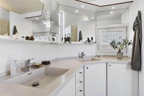 una cucina bianca con due lavandini e uno specchio di BL1555-Blokhus-Egebaeksvej-17 a Blokhus