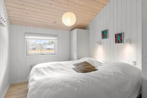 a bedroom with a large white bed with a window at BL1739-Blokhus-Bag-Hojen-47 in Blokhus