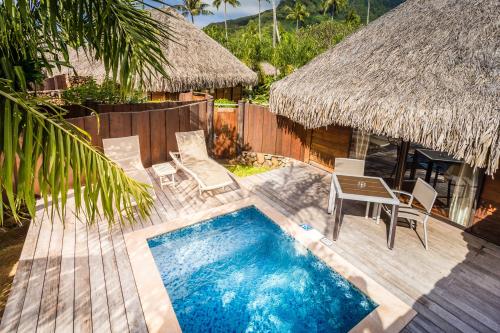 a resort with a swimming pool and a table and chairs at Manava Beach Resort & Spa Moorea in Maharepa