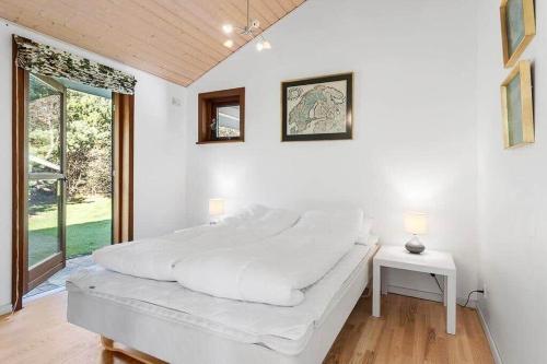 布洛克胡斯BL1718-Blokhus-Ronliensvej-16的一间带大床和窗户的白色卧室