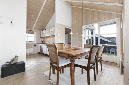 a kitchen and dining room with a wooden table and chairs at BL637-Blokhus-Klitvejen-35 in Blokhus