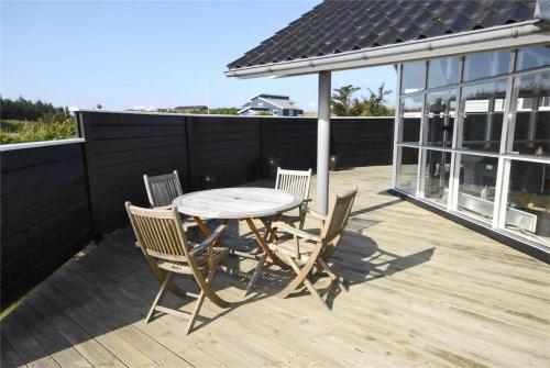 a wooden table and chairs on a deck at BL637-Blokhus-Klitvejen-35 in Blokhus