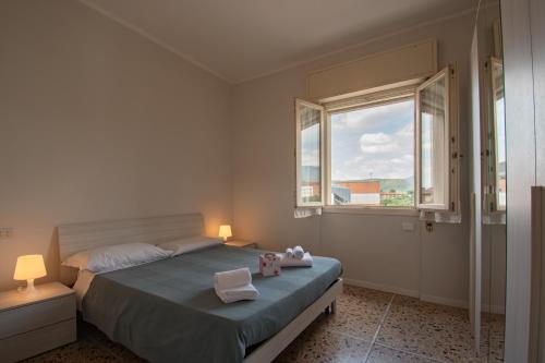 sypialnia z łóżkiem z ręcznikami i oknem w obiekcie Appartamento Ospedale Civile 3 - F&L Apartment w mieście Brescia