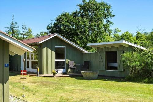 a small green house with a patio in a yard at BL1374-Saltum-Sydvestpassagen-8 in Saltum