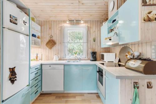a kitchen with blue cabinets and a sink at BL1213-Pandrup-Rodhusparken-14 in Pandrup
