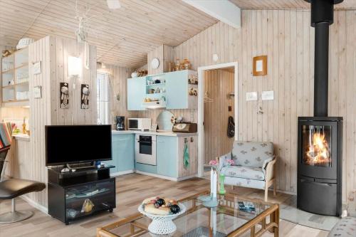 a living room with a television and a fireplace at BL1213-Pandrup-Rodhusparken-14 in Pandrup