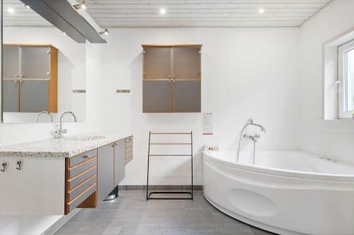 un bagno bianco con ampia vasca e lavandino di BL381-Blokhus-Maxvej-4 a Blokhus