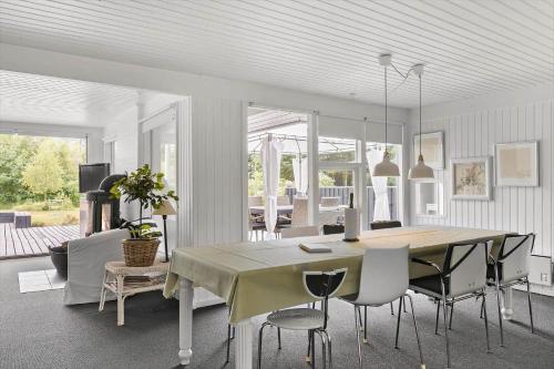 a dining room and living room with a table and chairs at BL1467-Saltum-Solmarken-4 in Saltum