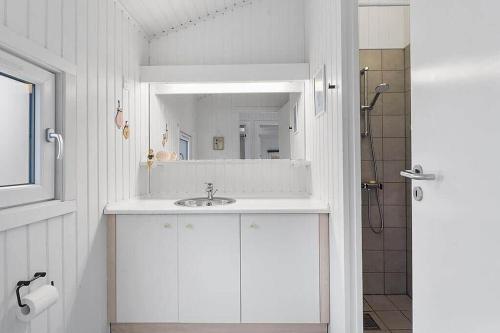a white bathroom with a sink and a mirror at BL738-Saltum-Graabakken-53 in Saltum