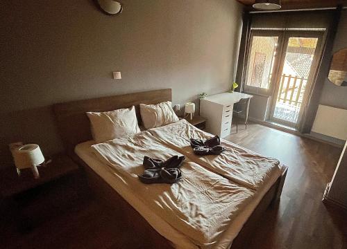 Un dormitorio con una cama con zapatos encima. en Silenzio Apartman, en Gyula