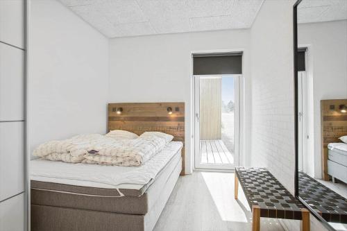 ein Schlafzimmer mit einem großen Bett und einem Balkon in der Unterkunft BL1405 Blokhus - Sletten 12 in Blokhus