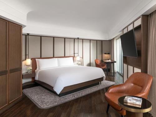 a hotel room with a bed and a chair at Fairmont Singapore in Singapore
