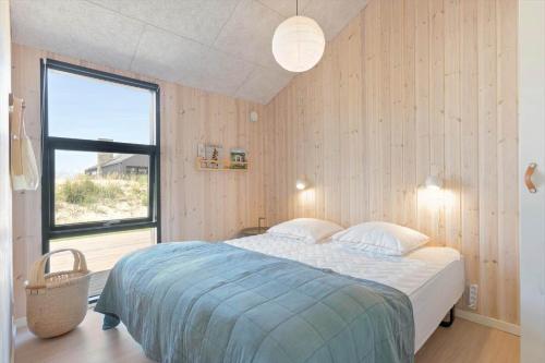 una camera da letto con un letto e una grande finestra di BL1489-Blokhus-Paa-Bakken-8-B a Blokhus