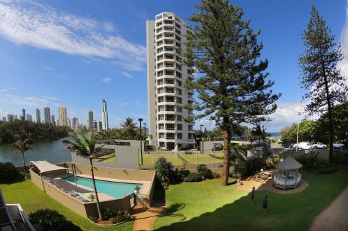 a large apartment building with a swimming pool and a tree at Narrowneck Court Holiday Apartments in Gold Coast