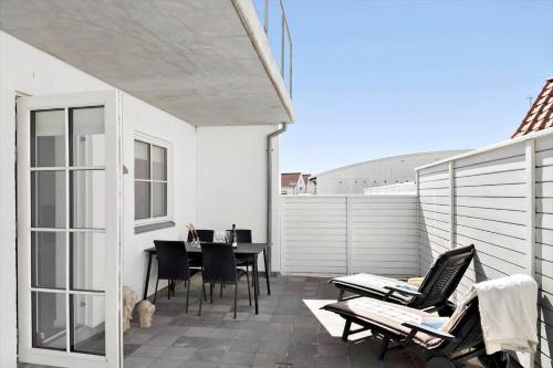a patio with chairs and a table on a balcony at BL1520-Blokhus-Klitgaardsvej-3-B in Blokhus