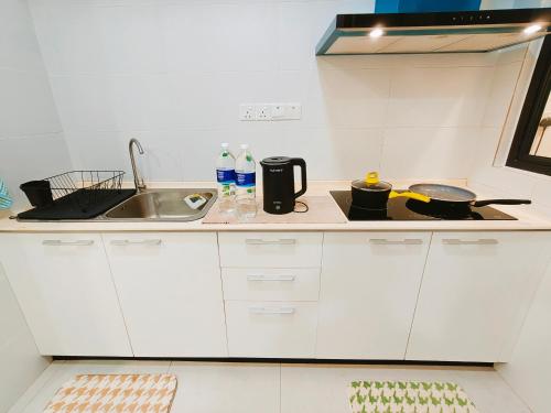 a small kitchen with white cabinets and a sink at SoulHealingPlace Galacity 2BR 2Bed Apartment in Kuching