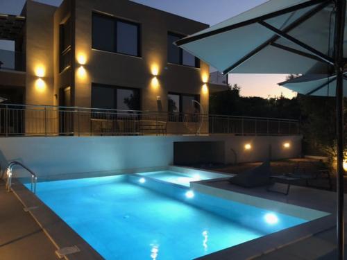 a swimming pool in front of a building with an umbrella at Allargo Project in Gerani
