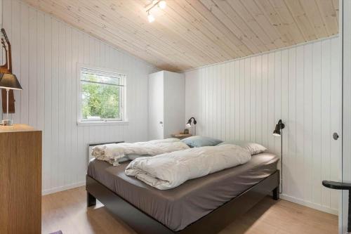 a bed in a bedroom with a wooden ceiling at BL1466-Pandrup-Lunekrogen-14 in Pandrup