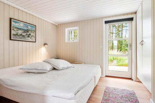 a white bedroom with a large bed and a window at BL1399-Saltum-Laustvej-30 in Saltum