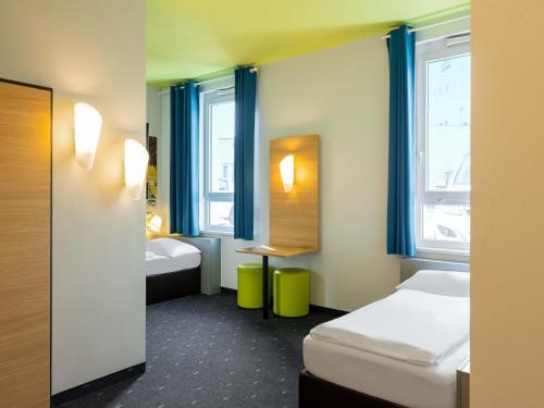 a hotel room with two beds and a window at B&B Hotel Mülheim an der Ruhr in Mülheim an der Ruhr
