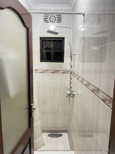 a shower with a glass door in a bathroom at Rhovee Arusha in Arusha