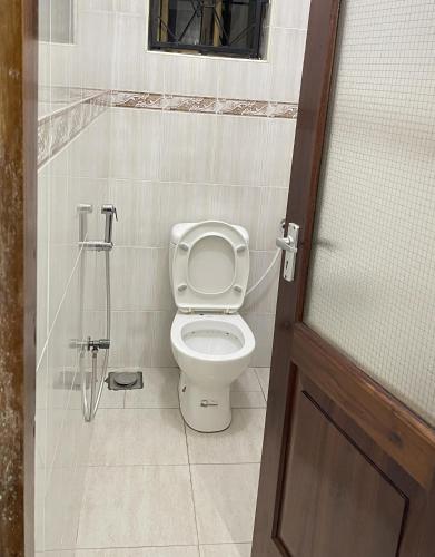 a bathroom with a toilet and a shower stall at Rhovee Arusha in Arusha