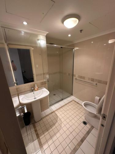 a bathroom with a shower and a toilet and a sink at Shared apartment in Regency Hyde Park in Sydney