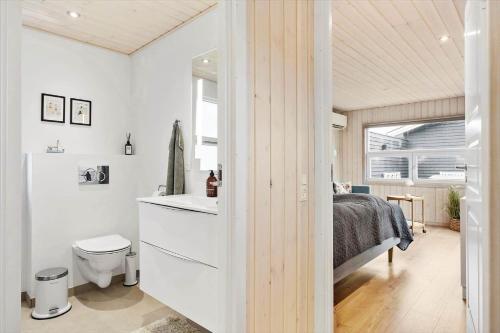 um quarto com uma cama, um WC e um lavatório em BL709-Blokhus-Kr-Thomsensvej-5 em Blokhus