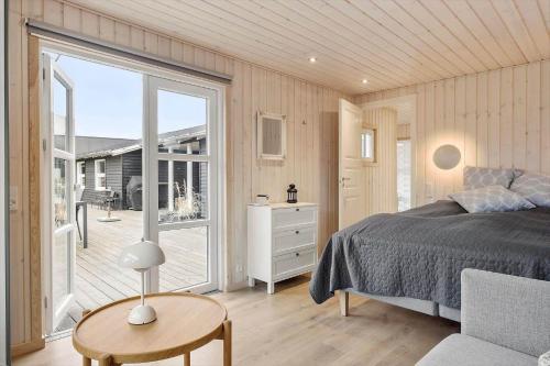 um quarto com uma cama e uma janela grande em BL709-Blokhus-Kr-Thomsensvej-5 em Blokhus